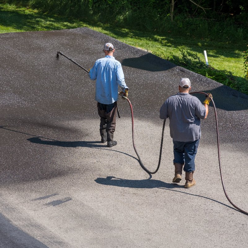 a layer of seal coating being applied to a driveway